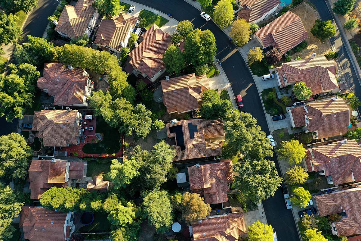 Vue aérienne d’un quartier résidentiel illustrant la proximité entre propriétés et les enjeux d’exposition visuelle autour d’une terrasse en bois.