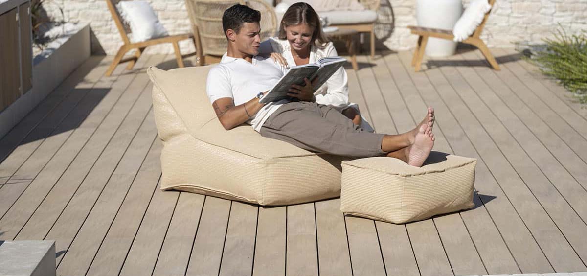 Terrasse en bois composite avec espace détente, fauteuils confortables et aménagement extérieur moderne.