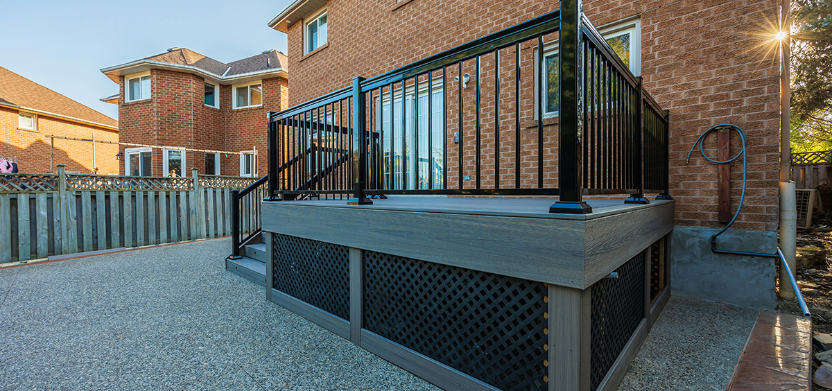 Terrasse en bois composite avec garde‑corps métallique noir sur maison en brique, design moderne et sécurisé.