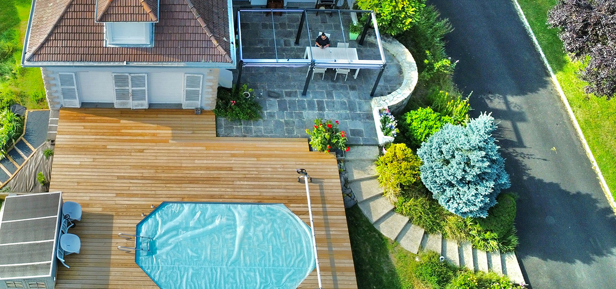 Vue aérienne d’une maison avec terrasse bois et piscine, illustrant la perception positive d’un bien immobilier entretenu et cohérent.